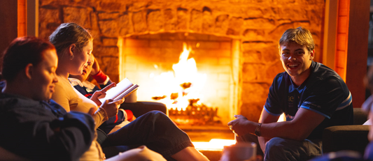 Refer a Friend promotion - Image of friends around a warm fire
